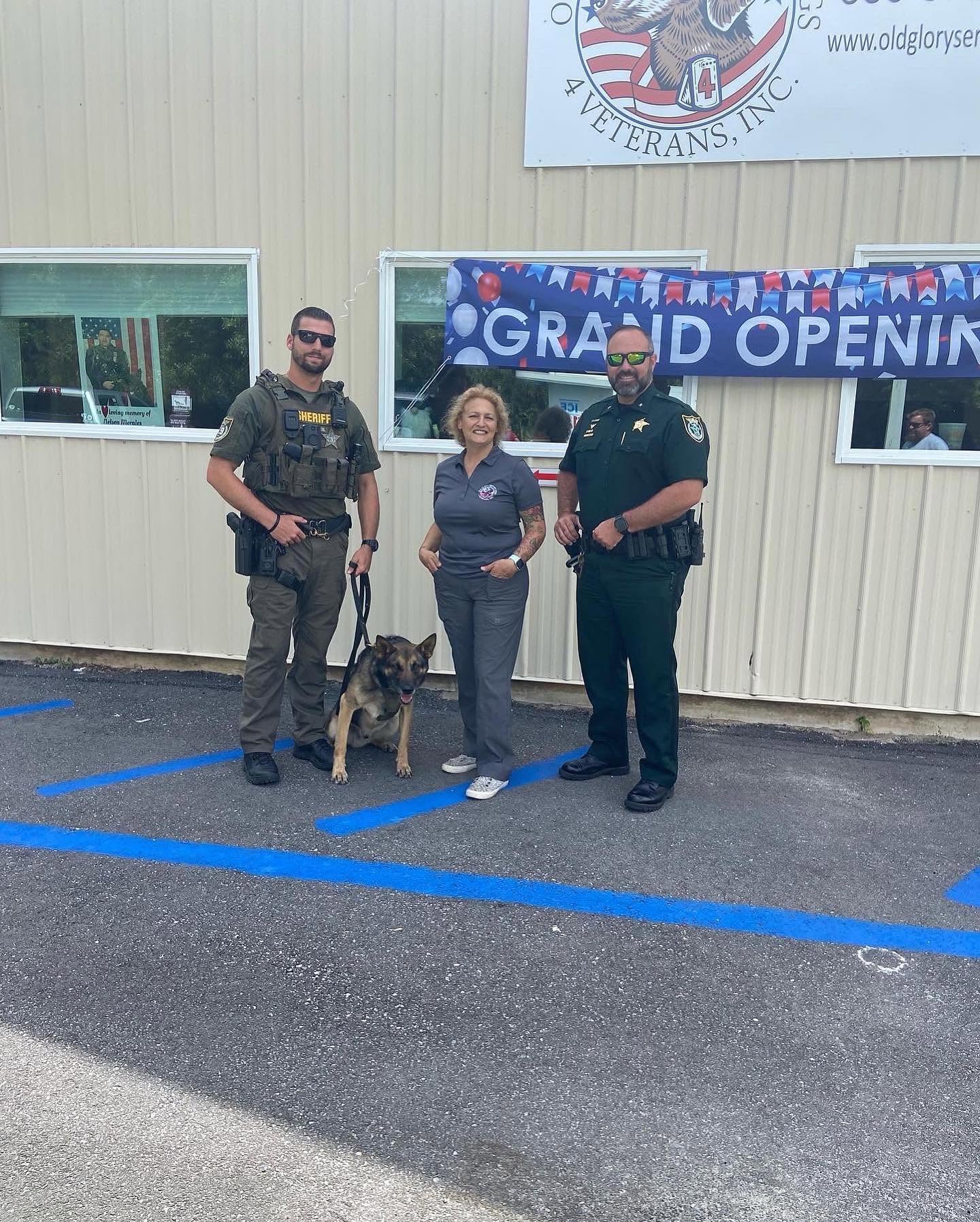 Lauren Driscoll with law enforcement representatives and a service dog at the Old Glory Service Dogs grand opening