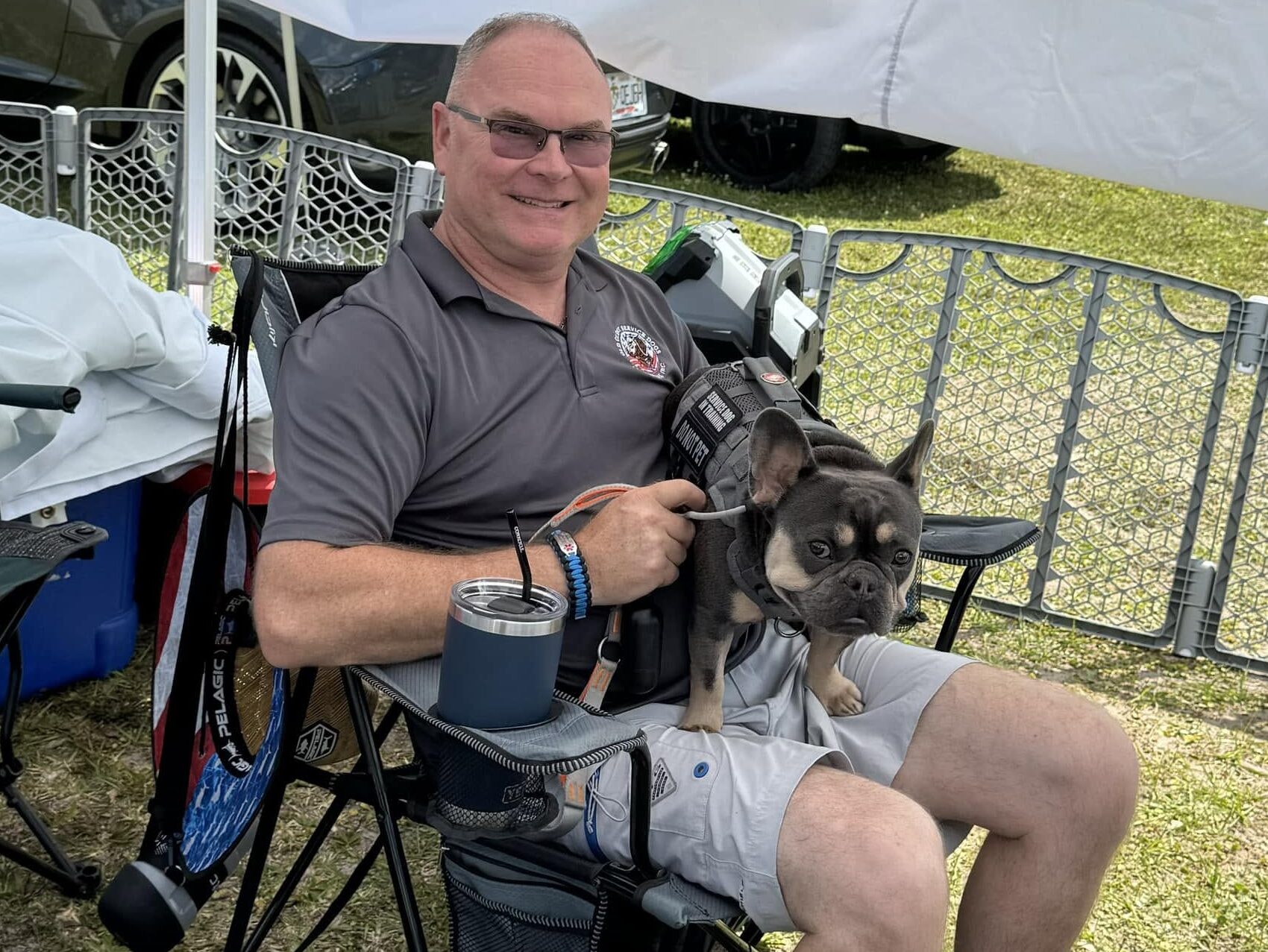 Old Glory member seated with his service dog during a community event
